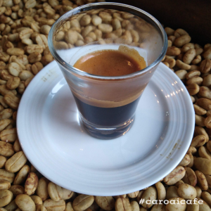 Espresso bien presentado sobre granos de café en pergamino